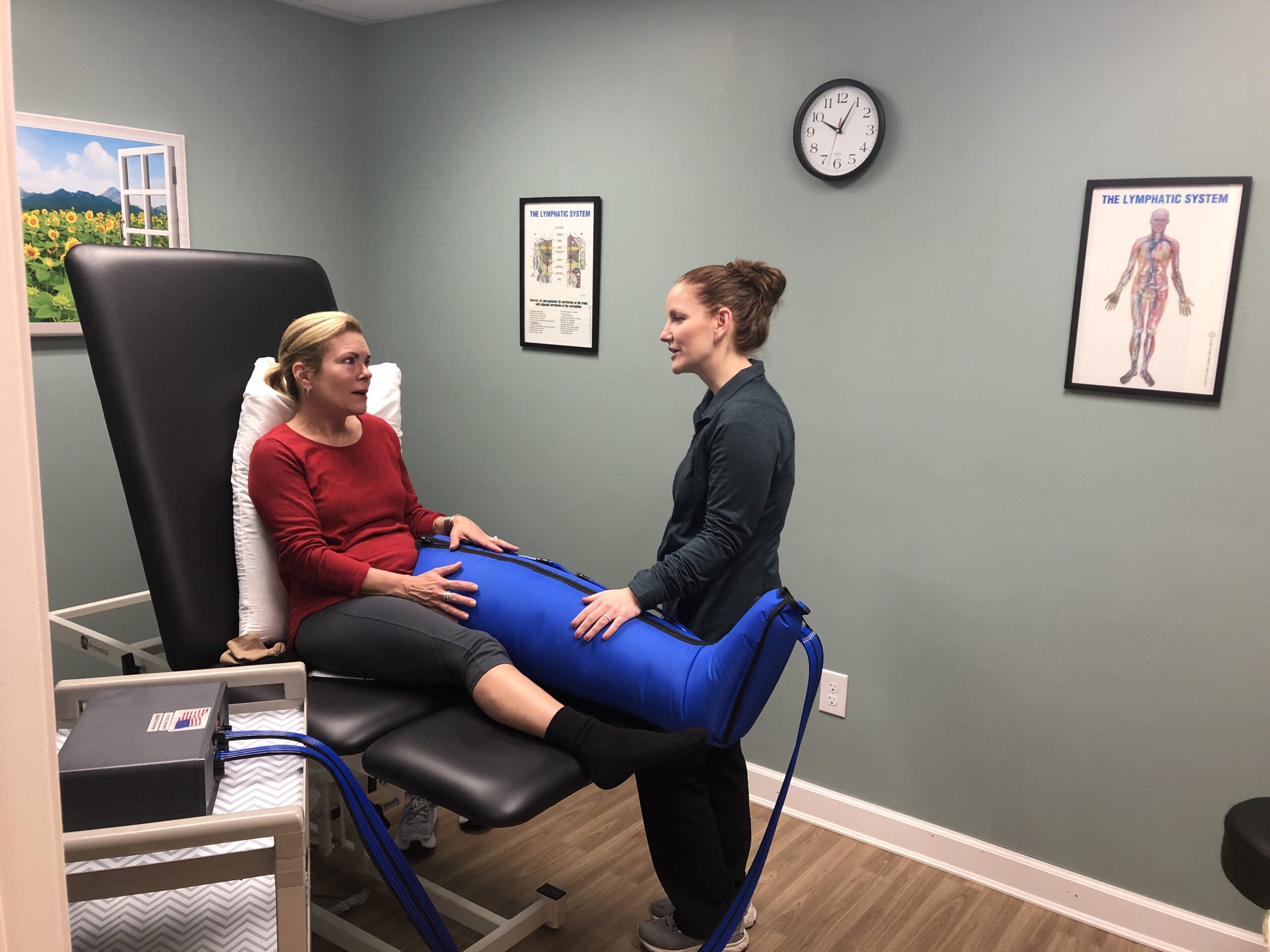 a woman sitting in a chair talking to another woman