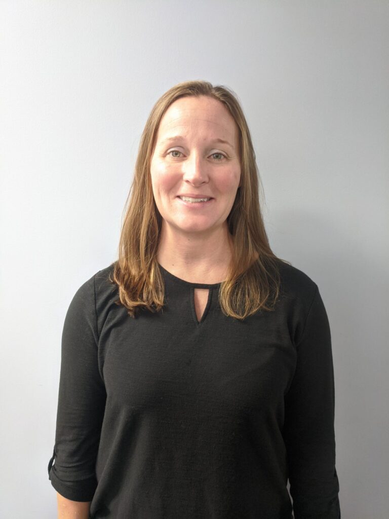 a woman standing in front of a white wall