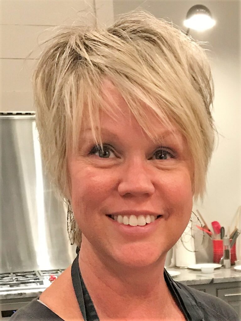 a woman with blonde hair smiling at the camera