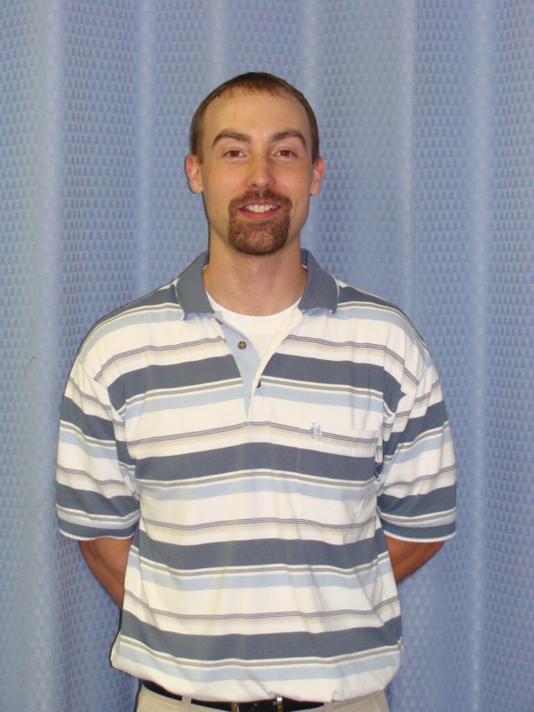 a man standing in front of a blue wall