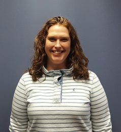 a woman standing in front of a blue wall