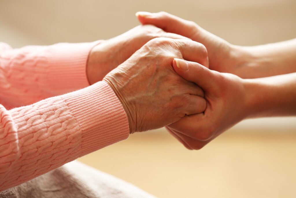 two people holding hands while sitting down