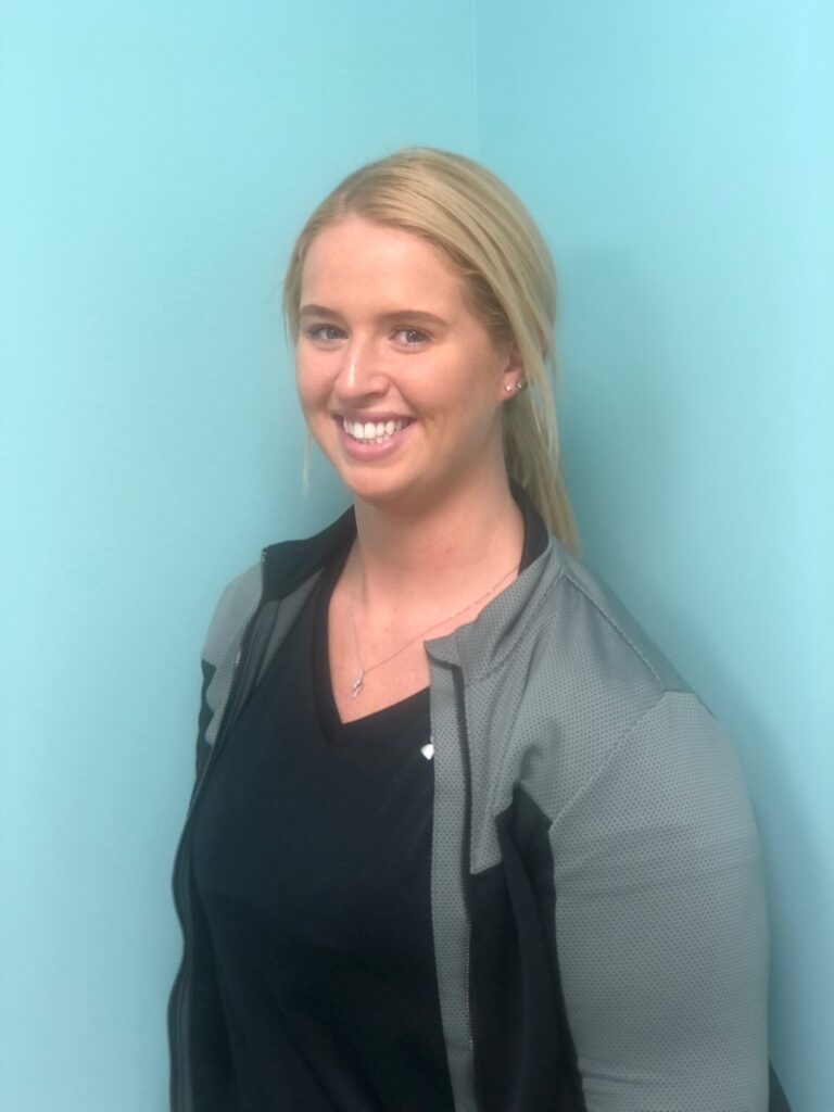 a woman standing in front of a blue wall