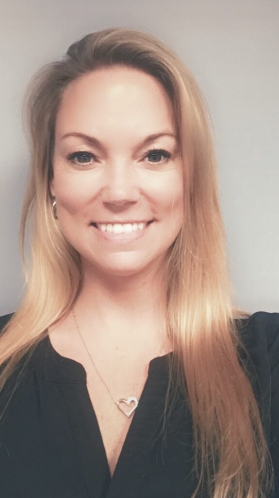 a woman with long blonde hair smiling at the camera