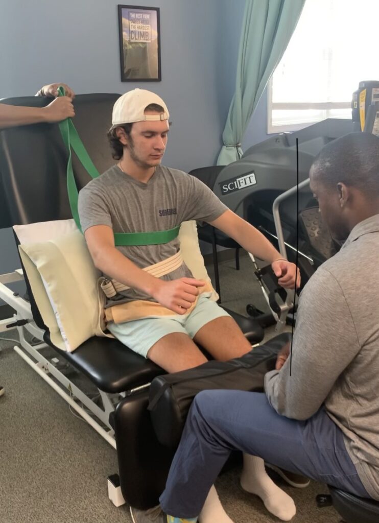 a man sitting in a chair with another man