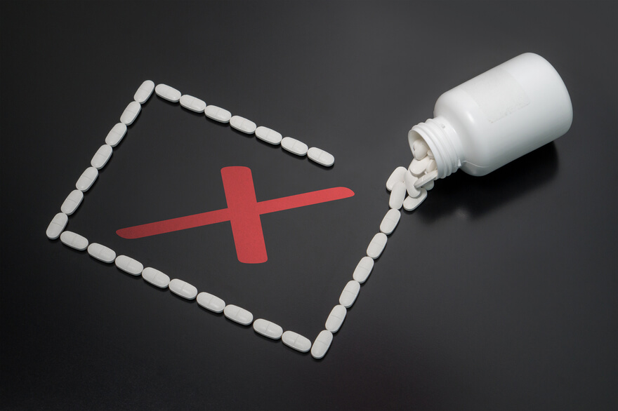 a bottle of pills with a red cross on it