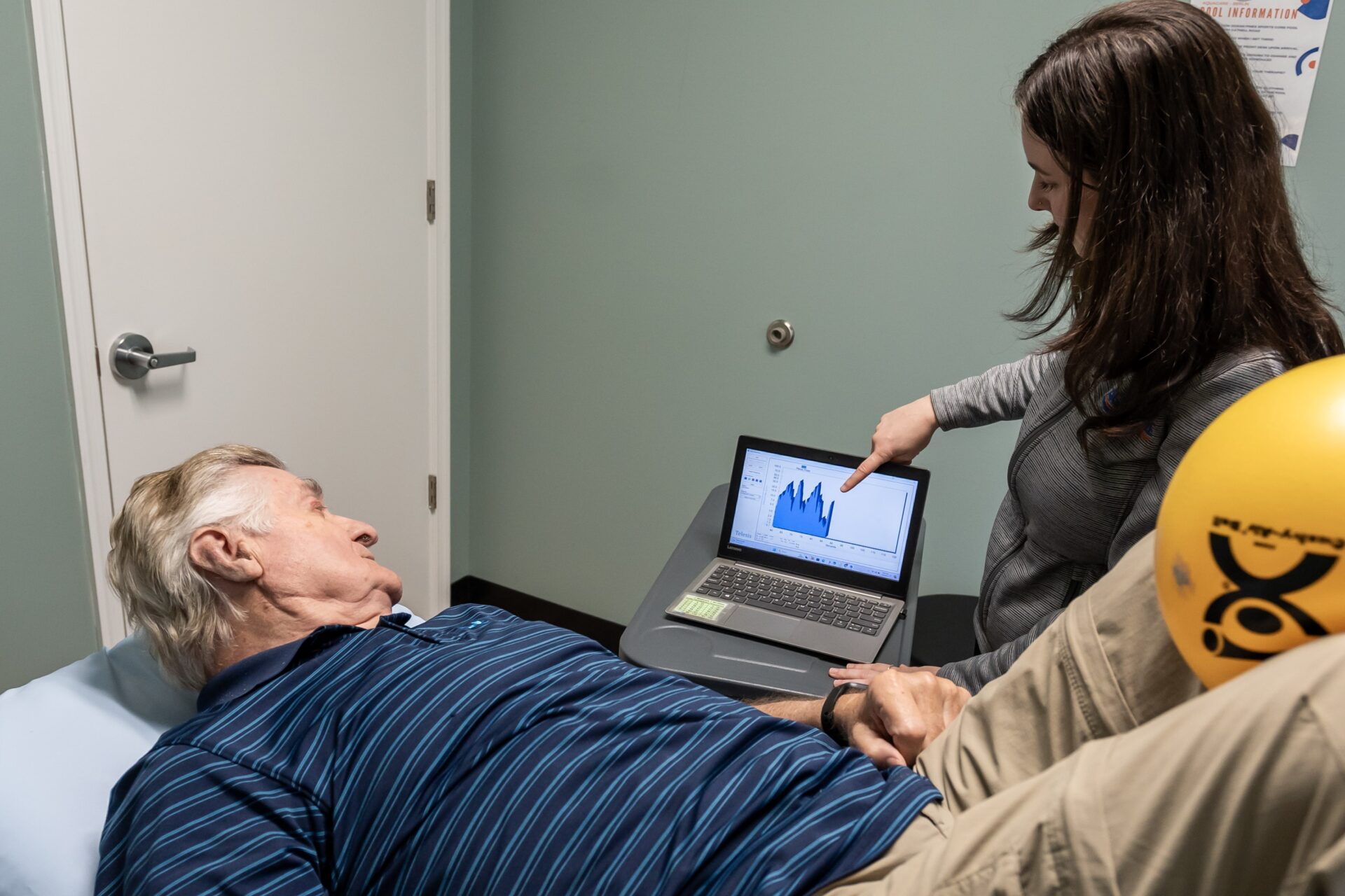 a man laying in a bed with a laptop on his lap