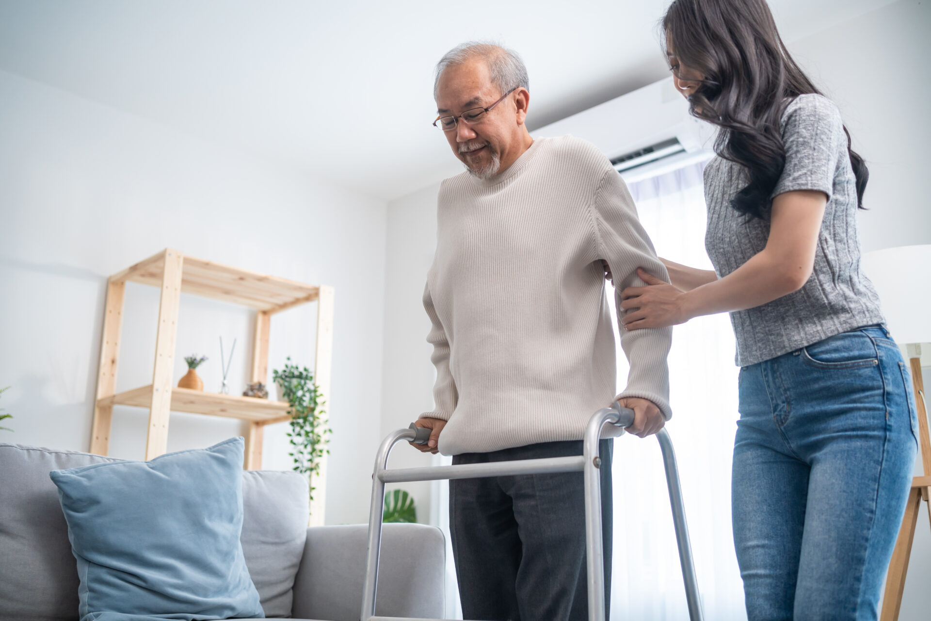a woman helping an elderly man with a walker