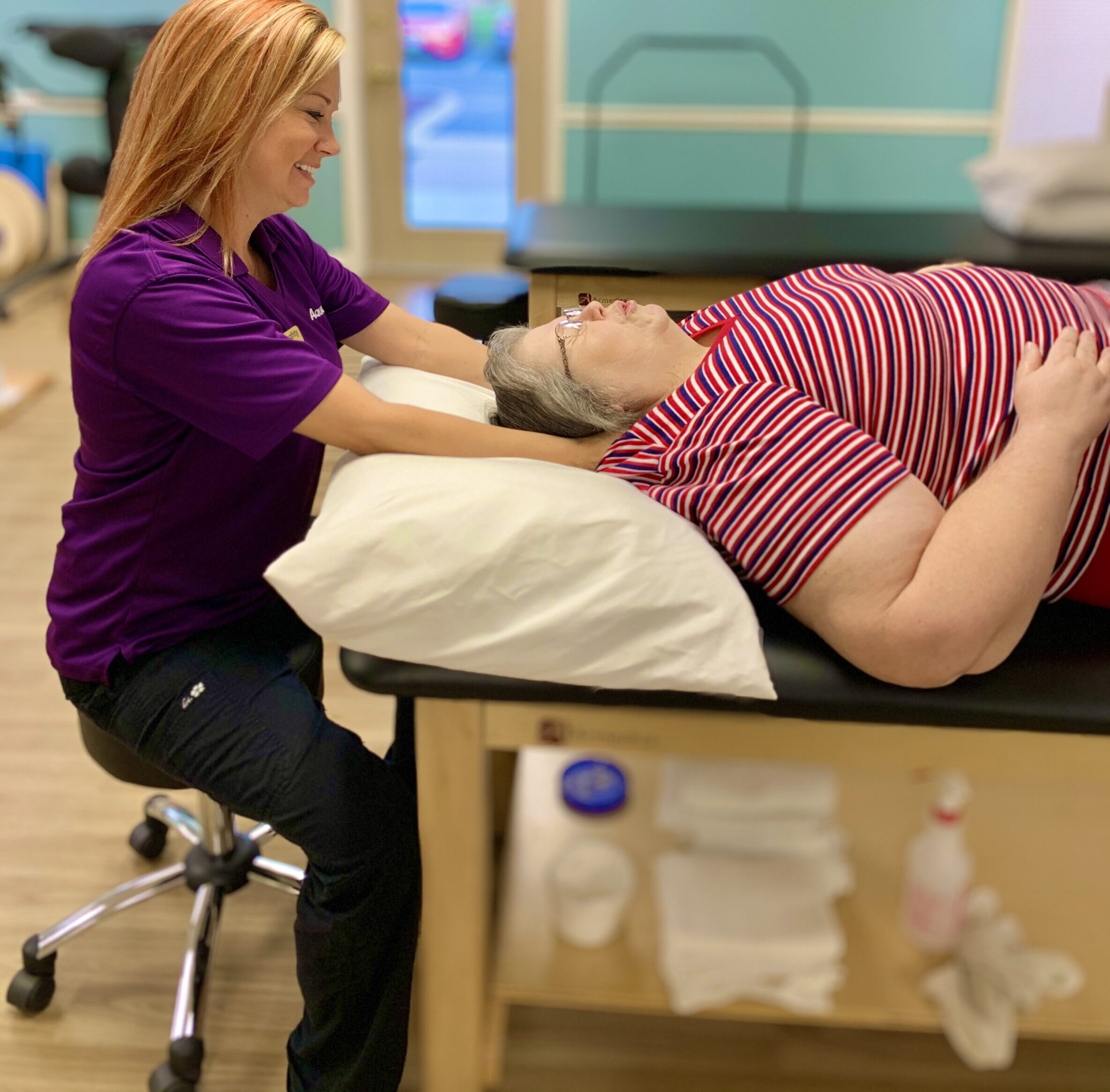 a woman is getting a back massage from a doctor