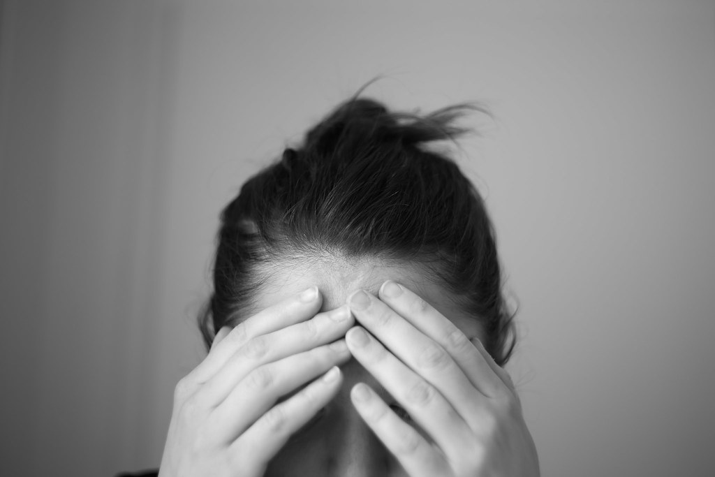a woman covering her eyes with both hands