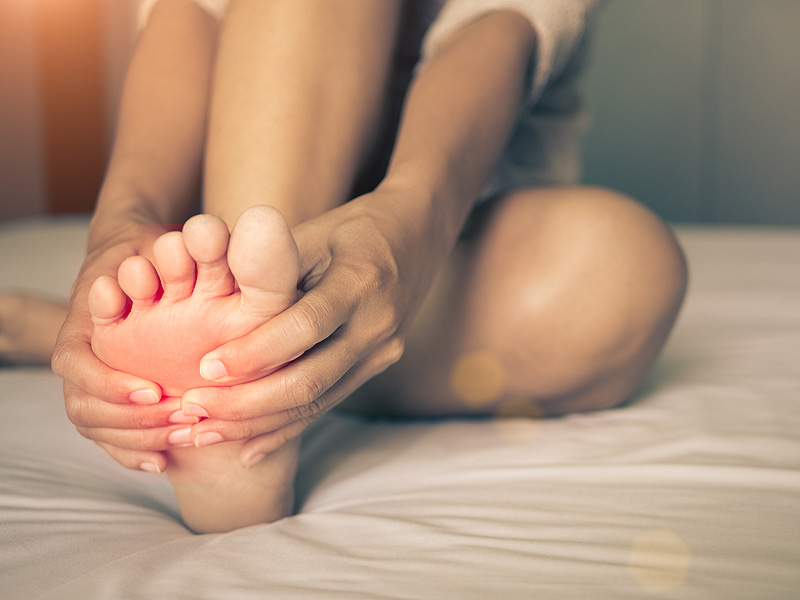 a woman sitting on a bed with her feet up
