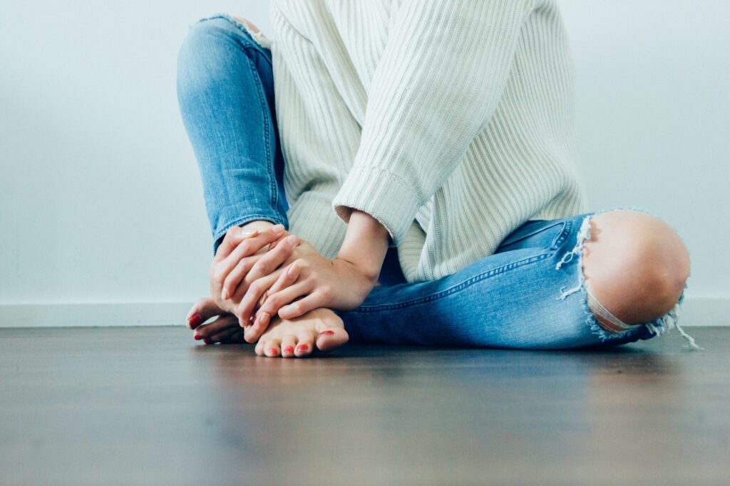 a woman sitting on the floor with her hands in her knees
