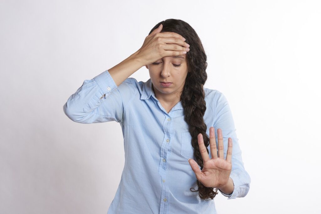 a woman holding her hands up to her head