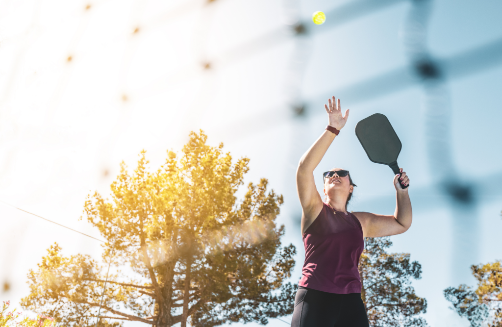 person holding a pickleball paddle on a court