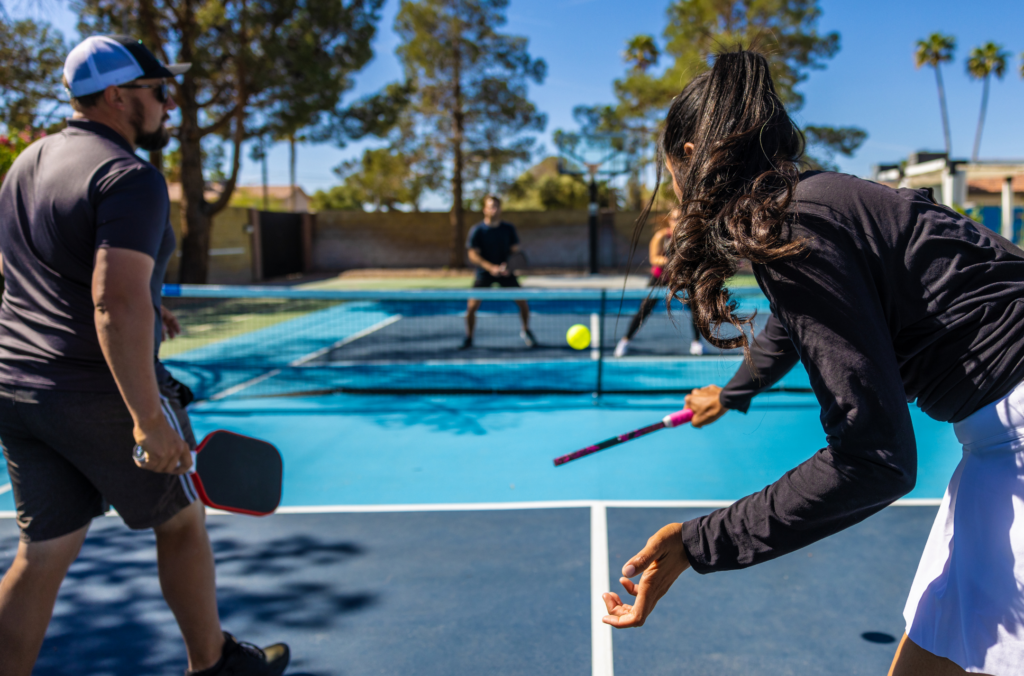 a man and woman playing pickleball on a court