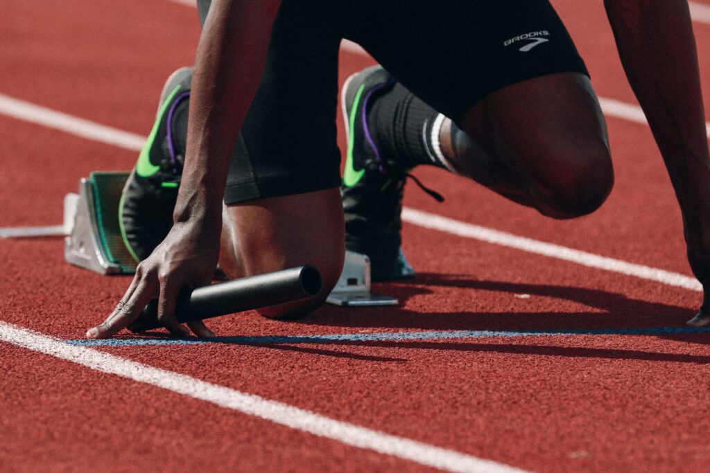 a man kneeling down on top of a race track